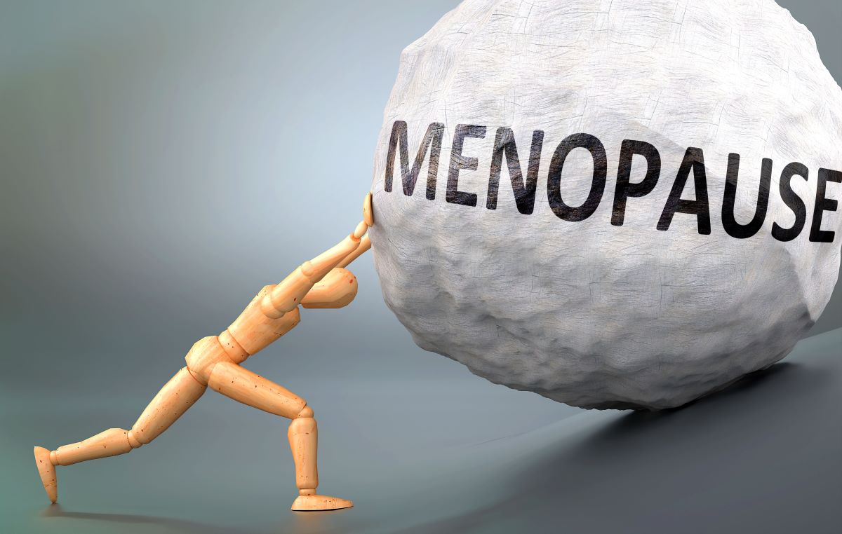 a man pushing a ball with menopause written on it